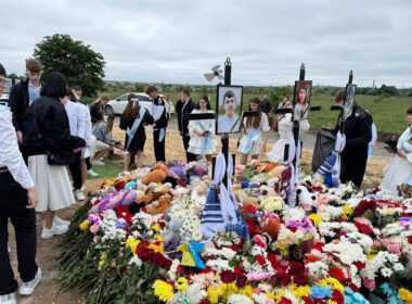 Ukrainian high school students visit a gravesite of their classmate and his two siblings killed by a Russian missile strike. Their class teacher conducts a "last bell" graduation ceremony for the oldest of the siblings, Roman.